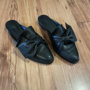 Black faux-leather mules w/ how detail